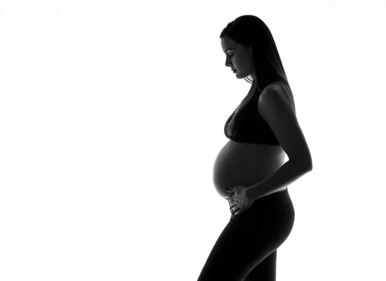 photo en noir et blanc d'une femme enceinte sur fond blanc par RDMPHOTOS et RDMSTUDIO